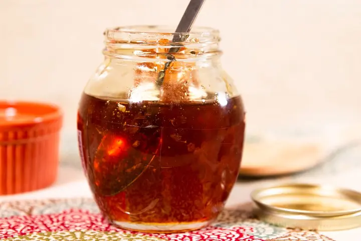 A small jar of honey with honeycomb